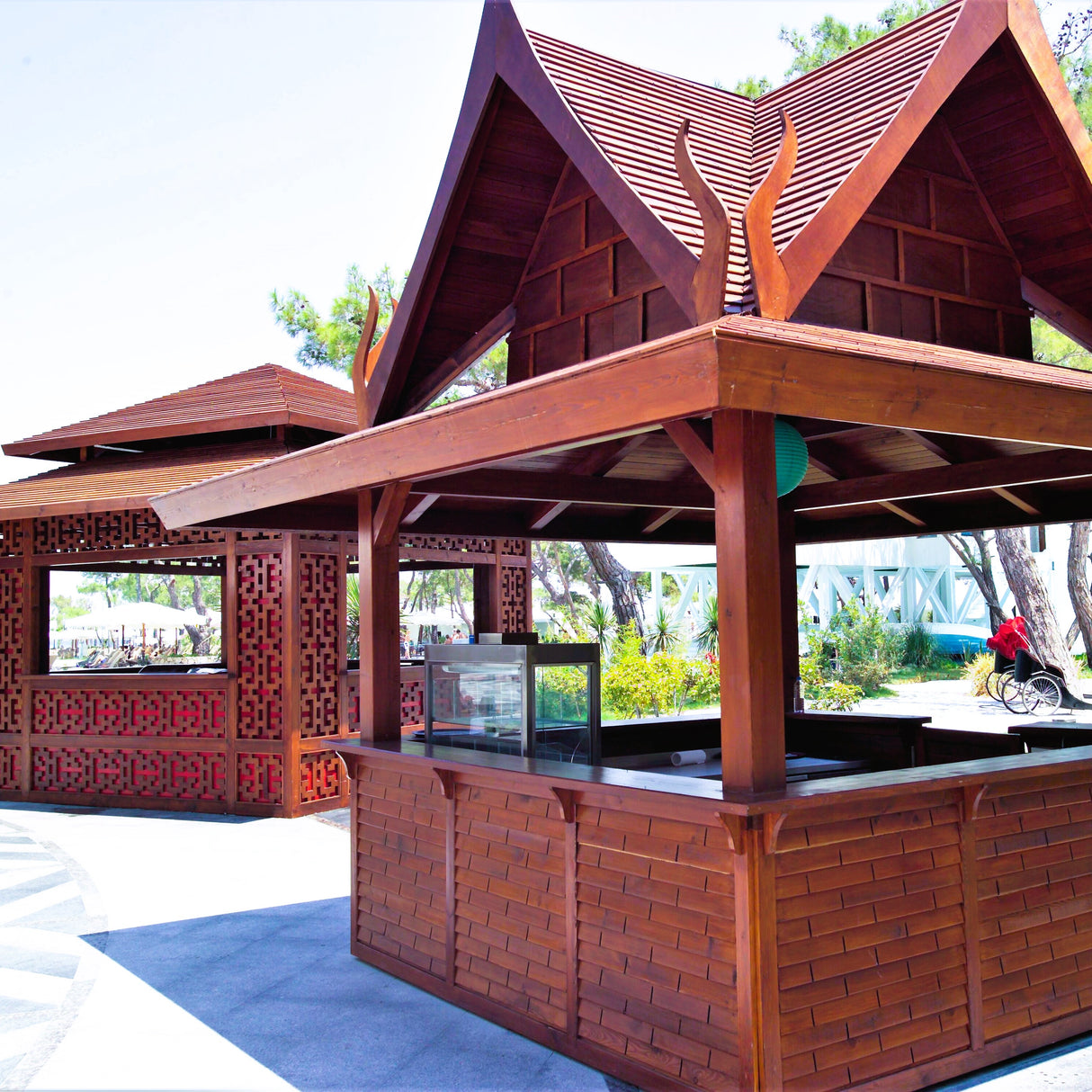 Cenadores de madera para exteriores con mesas y taburetes de mármol. Obras de acondicionamiento en Antalya, Turquía. Espacios de comedor de inspiración asiática.